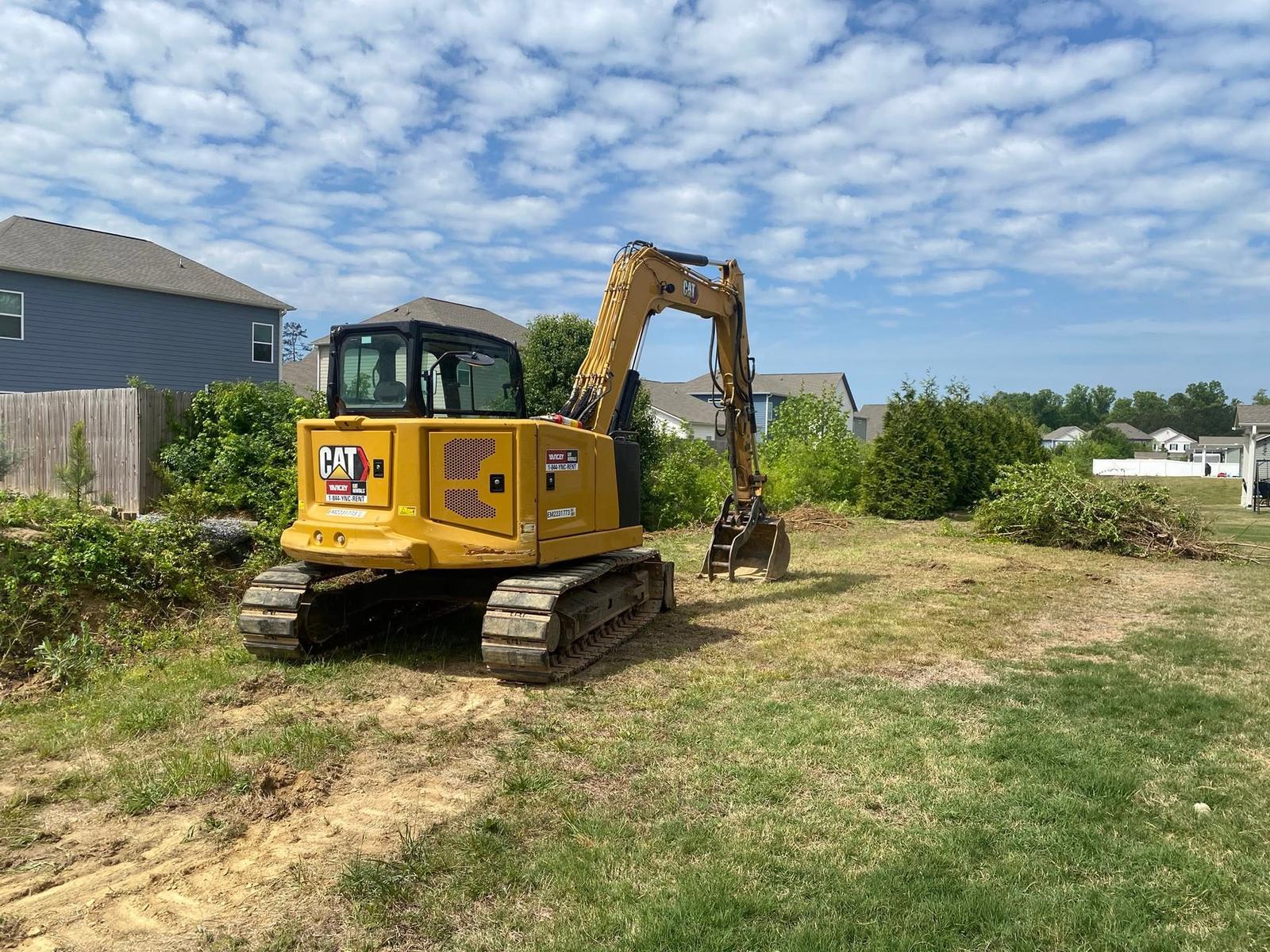 Mini excavator working in a green residential yard