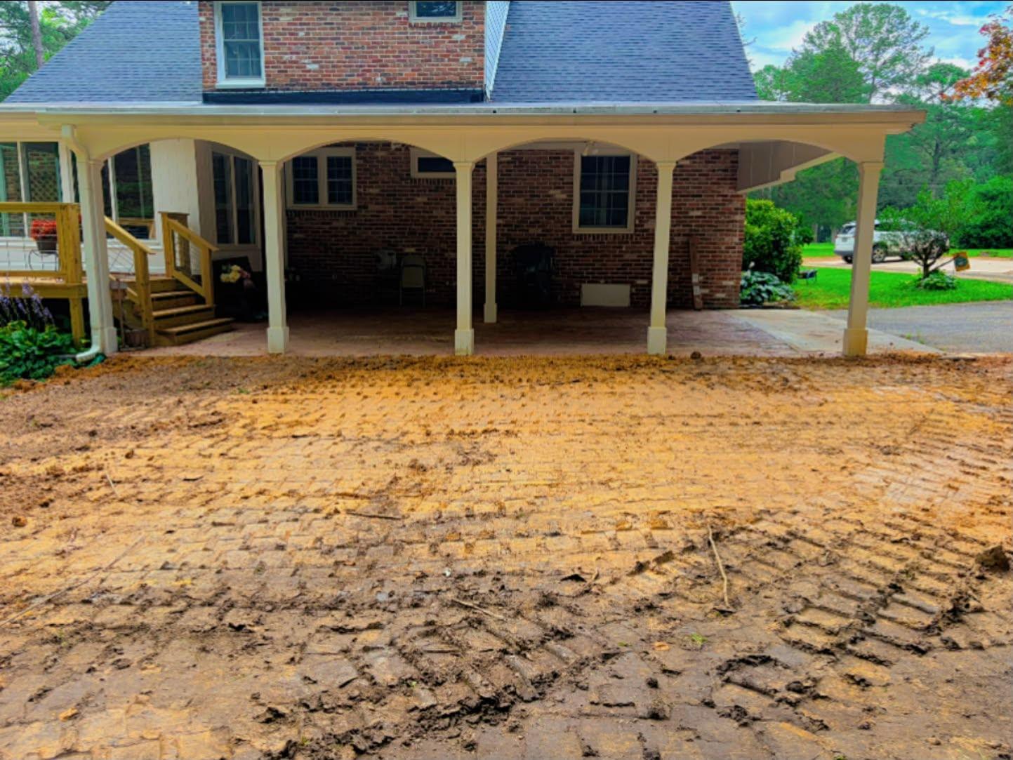 Finished graded pad beside a covered patio at a brick home