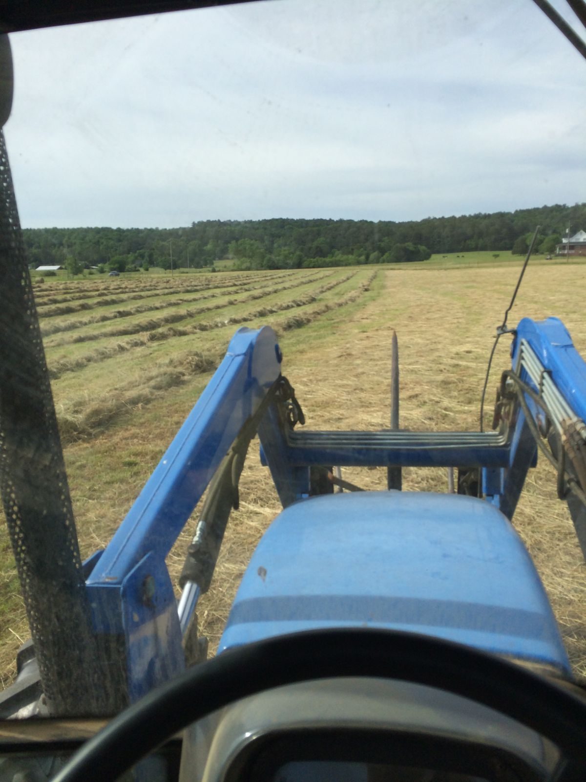 View from the tractor cab raking hay on the family farm in Cave Spring, Georgia
