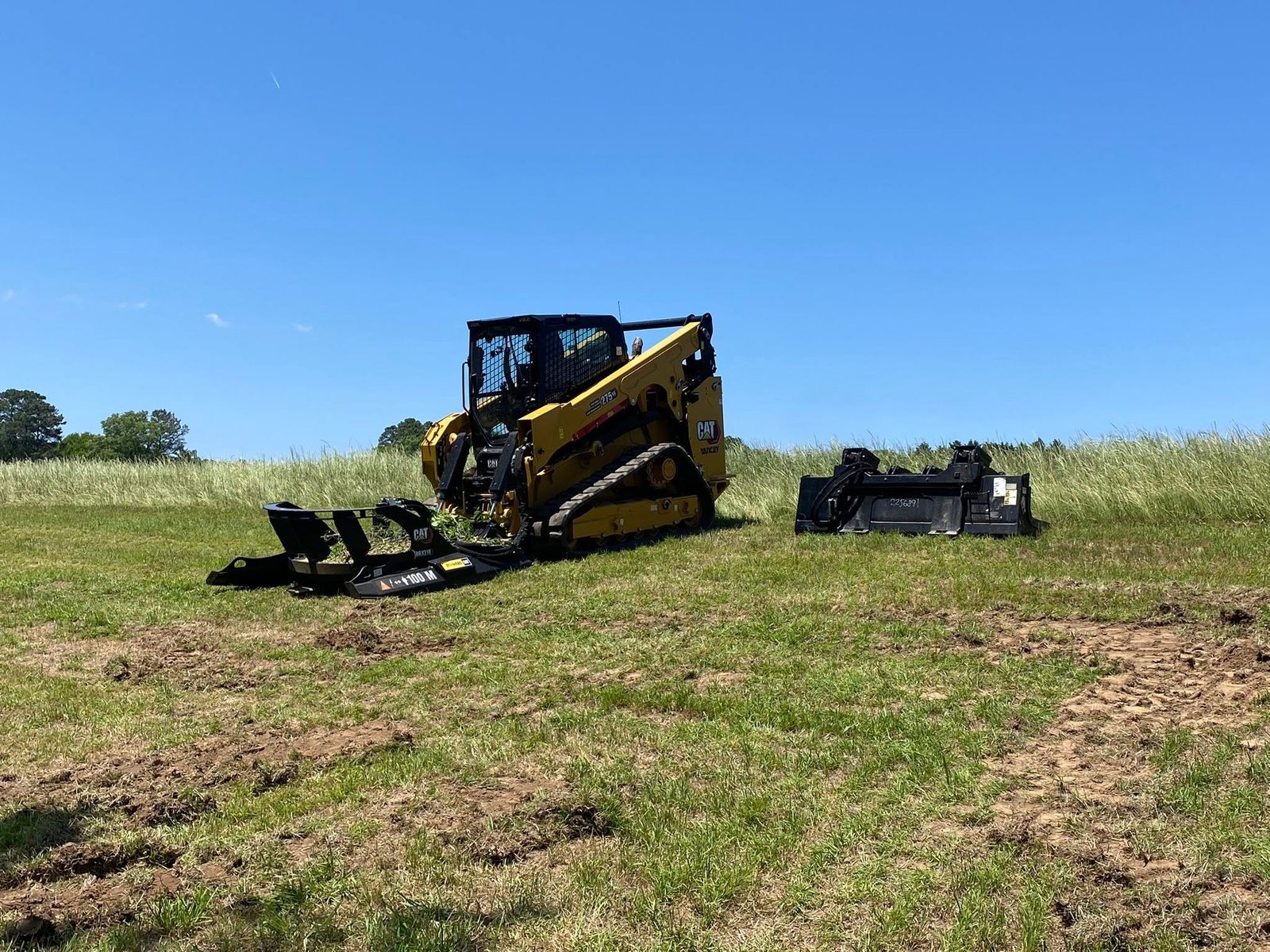 CAT compact track loader working in an open field